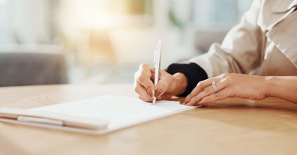 Decálogo del reutilizador de datos del sector público Mano que sostiene un bolígrafo plateado y escribe sobre una hoja sobre una mesa.